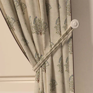 A close-up of the Mithoo Pipin curtain tied back, highlighting its crisp piped edge and the gentle pattern on the folded fabric.