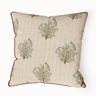 Mithoo Pipin cushion cover featuring a repeating pattern of small blue birds on branches with a clean, brown piped edge.