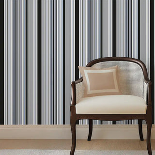 Modern Black & Grey Layered Stripe Wallpaper Roll featured behind a classic cushioned chair, highlighting the bold vertical lines in contrasting shades.