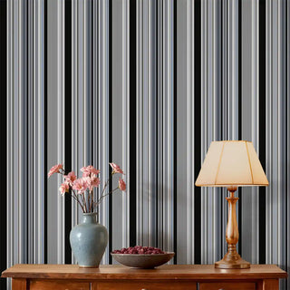 Living room styled with Modern Black & Grey Layered Stripe Wallpaper Roll, paired with a wooden console, ceramic vase with flowers, and a warm table lamp.
