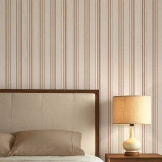 Bedroom styled with Modern Brown & Beige Wide Stripe Wallpaper Roll featuring alternating wide brown and beige vertical stripes, paired with a neutral bedframe and bedside lamp.