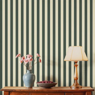 Modern Green & Beige Wide Stripe Wallpaper Roll covering a living room wall, styled with a classic console table, lamp, and floral vase for a cozy touch.