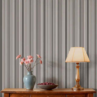 Living room styled with Modern Grey Layered Stripe Wallpaper Roll behind a wooden console table, lamp, and vase with pink flowers.