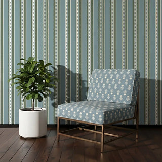 Mogra upholstery fabric in teal blue on a brass-framed accent chair beside a fiddle leaf fig, against beaded striped walls in a living room corner.
