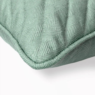 Close-up of the Moss Drift Cushion corner showing the herringbone texture and piping.
