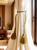 Mosswood Luxe moss-green tassel tieback with beaded accents on cream linen