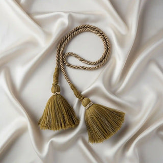Flat lay of the Mosswood Luxe Tassel showing the deep olive green tassels with beaded trim and the braided gold/beige cord.