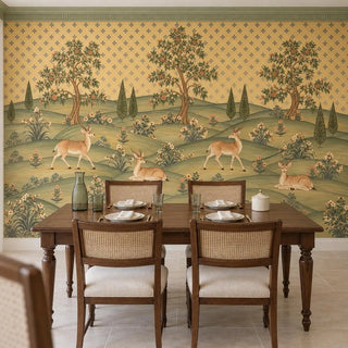 The Mriga Vatika Pichwai wallpaper behind a walnut dining table with cane-back chairs, spotted deer and flowering trees above view-dining