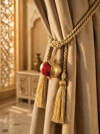 The Nar pomegranate gold curtain tieback styled around a heavy beige linen curtain panel inside a luxury heritage palace interior.