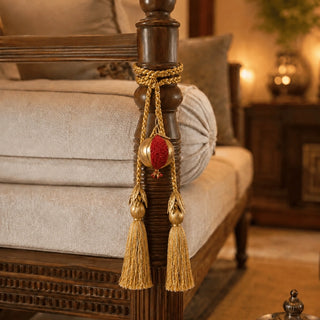 Nar pomegranate tieback tied around a carved wooden bedpost beside upholstered bedding