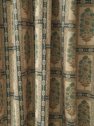 close-up detail of the Nayab curtain fabric showing teal floral butas inside geometric borders on a cream ground.