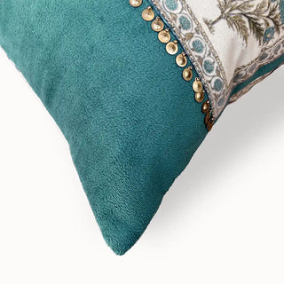 A close-up detail of the hand-stitched gold coin fringe and deep teal velvet texture on the Nayab cushion.