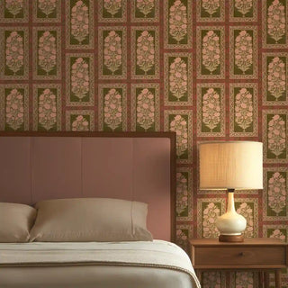 Nayab Mughal-style floral wallpaper styled in a luxury bedroom behind a dusty pink headboard and wooden side table.