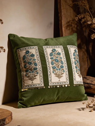 Front view of the Nayab cushion featuring olive velvet, three floral embroidery panels, and gold coin charms.