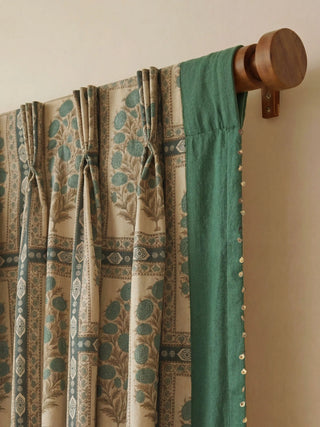 Nayab Readymade Curtain in Mughal Floral readymade curtain, Close-up of the professional pinch-pleat tailoring and teal velvet header mounted on a dark wooden curtain rod.