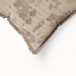 A close-up of the Nritya Fringes cushion cover, showing the intricate fringed edge and the detailed, tone-on-tone natural motif of trees and subtle figures.