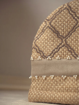 Close up of the woven jute texture, diamond stitching and pearl bead trim on the Oat Pearl tea cosy