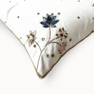 A detailed close-up of the Padma Leela cushion highlighting the sapphire and pink sequin petals and textured gold stems.
