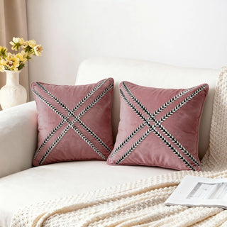 a pair of cross braided blush cushions decorating a light-colored living room sofa
