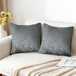 Two Gilded Echo Cushion Covers styled on a white sofa with a knitted throw.