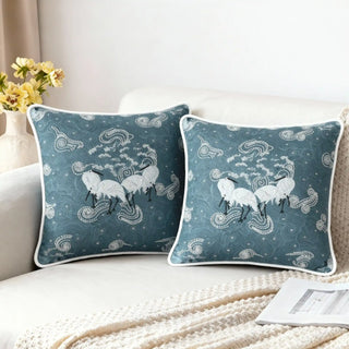 Two Graceful Cranes Azure Cushion Covers styled on a white sofa with a knitted throw.