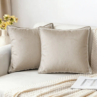Two Serra Bloom Dew Cushion Covers styled on a white sofa with a knitted throw.