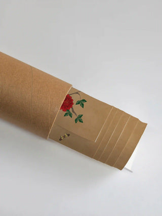 Premium protective shipping tube showing the rolled Pakhi art print and its vibrant red flower detail.