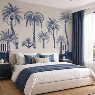 The Palmyra Breeze wallpaper mural in Cyanotype on a bedroom feature wall, showing navy-and-white patterned-trunk palms above rolling hills. view-bedroom