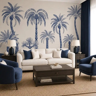 The Palmyra Breeze wallpaper mural in Cyanotype covering a feature wall in a living room in navy and white, behind a cream sofa and navy armchairs. view-livingroom