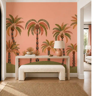The Palmyra Breeze wallpaper mural in Peach on an entryway wall, showing patterned-trunk palms on a coral-peach ground, behind a console table. view-foyer