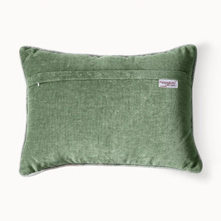 A high-definition close-up showing the tactile texture of the embroidered parrots and the shimmering pistachio velvet.