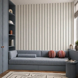 The Pebble Stripe cream grey wallpaper installed behind a blue ribbed daybed sofa and built-in blue bookshelf in a living room view-livingroom
