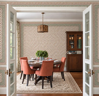 The Pera Vintage Ottoman green wallpaper covering a dining room's walls and ceiling border, with a round table and terracotta chairs. view-dining