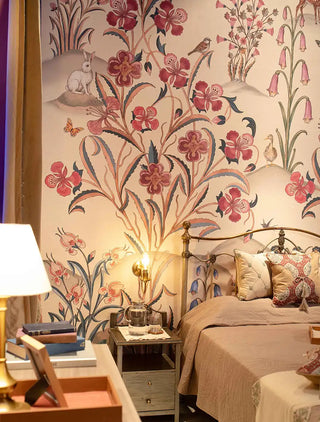 The Petals of Persia wallpaper mural with crimson flowers, pink bell flowers, a rabbit and a duck, beside a brass bed and a bedside table with a water jug. view-bedroom