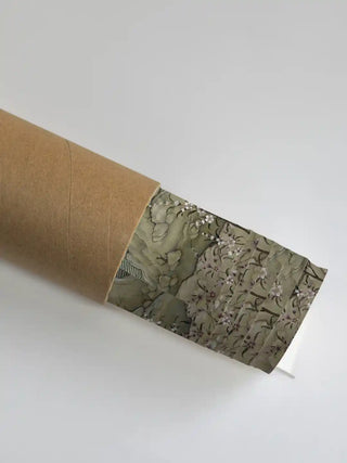 Phoenix wall art print in antique sage rolled in a kraft shipping tube, showing the blossom branch and rockwork detail.