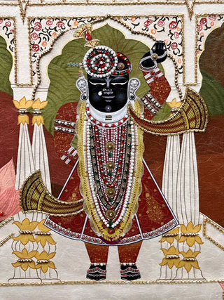 A detailed close-up of the Pichwai Palace embroidered wall art highlighting Shrinathji’s beadwork garlands, jewelled turban and gold-edged arches