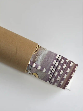 The Pichwai Palace embroidered wall art print partly unrolled from its kraft paper shipping tube, showing the plum lotus border and gold detail