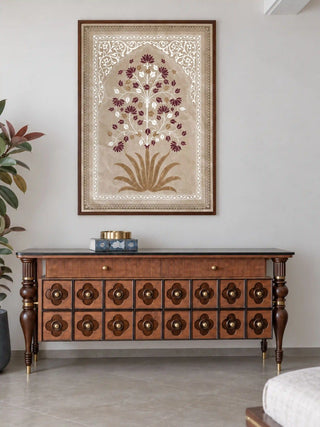 The Pietra wall art in a dark wood frame above a carved walnut console with four-lobed drawer fronts, brass knobs and a brass dish.