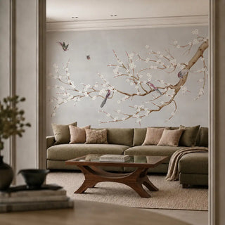 The Plum Blossom Grey luxury wallpaper mural installed as a main accent wall behind an olive green sectional sofa in a modern living room view-livingroom