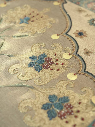 Bagh-e-Noor embroidered wall art close-ups: blue and red floral motifs, gold sequins and a scalloped arch border in soft neutral tones