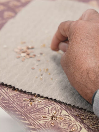 Video of Geet Madhubani embroidered wall art in rust and gold, showing hand-stitched folk motifs and birds around a Madhubani elephant