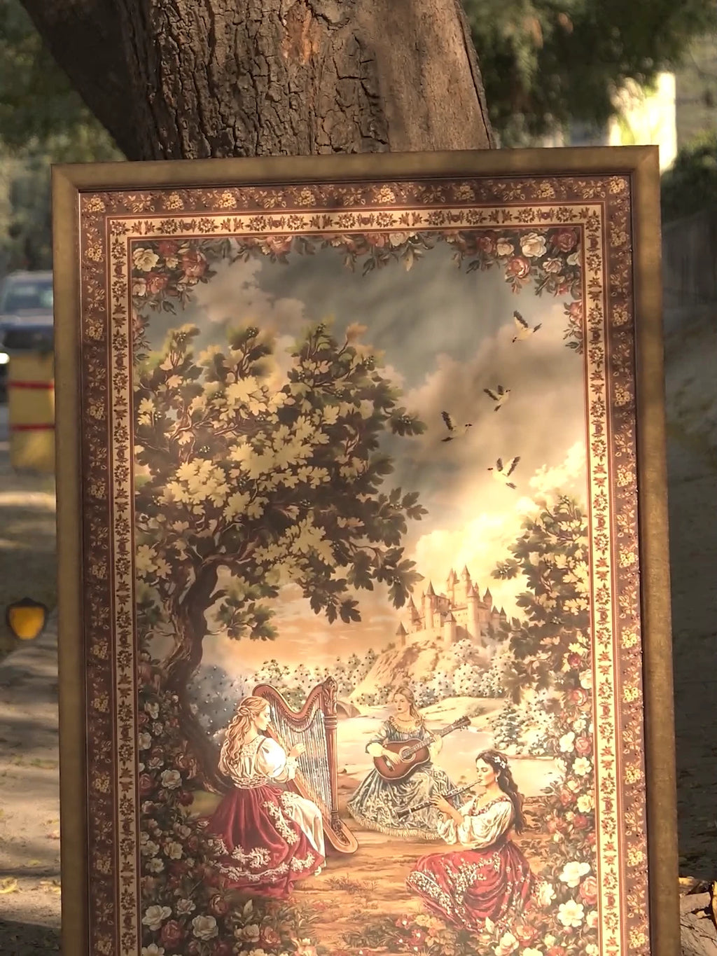 Video of Garden of Tunes embroidered wall art in burgundy, forest green and sky blue, showing needlework on the harpist, flutist and rose garden beneath towering oaks