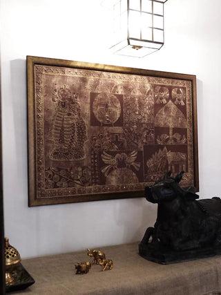 Geet Madhubani embroidered wall art in rust and copper, framed on a white wall beside a dark sculpture, filmed from several angles