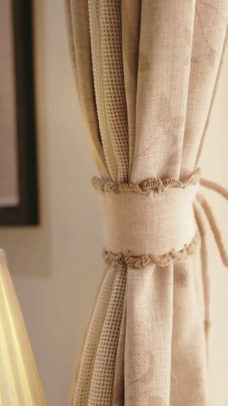 Hazel Verse curtain tie-back in ivory linen with scalloped crochet edging, gathering a beige curtain, with a close look at the trim