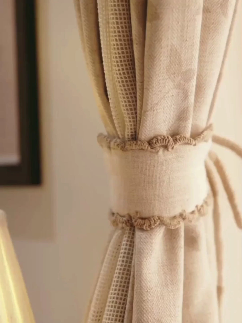 Hazel Verse curtain tie-back in ivory linen with scalloped crochet edging, gathering a beige curtain, with a close look at the trim
