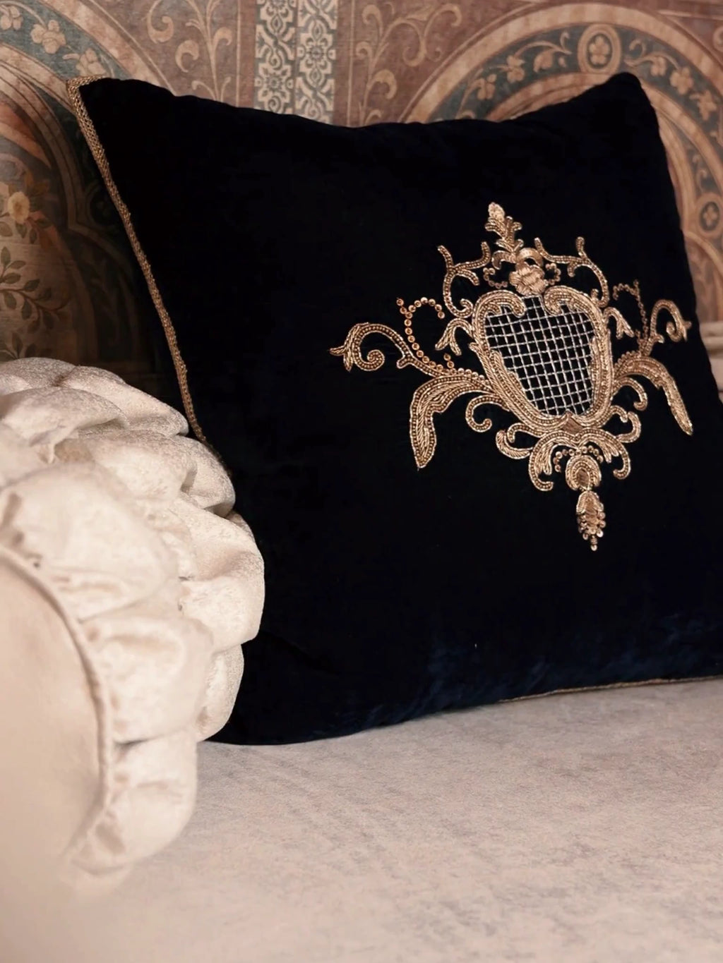 Close-up video of the Jewels of Nizam cushion cover in blue velvet, moving over the gold zardosi embroidered crest with its latticed centre