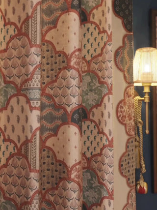Mehr Mahal readymade curtains with a patchwork of scalloped arches in terracotta and sage, hung beside brass sconces on a blue wall