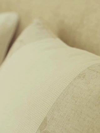 Close view of the Prose Pattern cushion cover showing its textured ivory weave panel beside a beige panel with a soft leaf-vine print