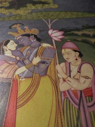 Close-up video of the Radha Krishna landscape wall art, moving over the embracing couple, the attendant, a heron in the tree and the floral border