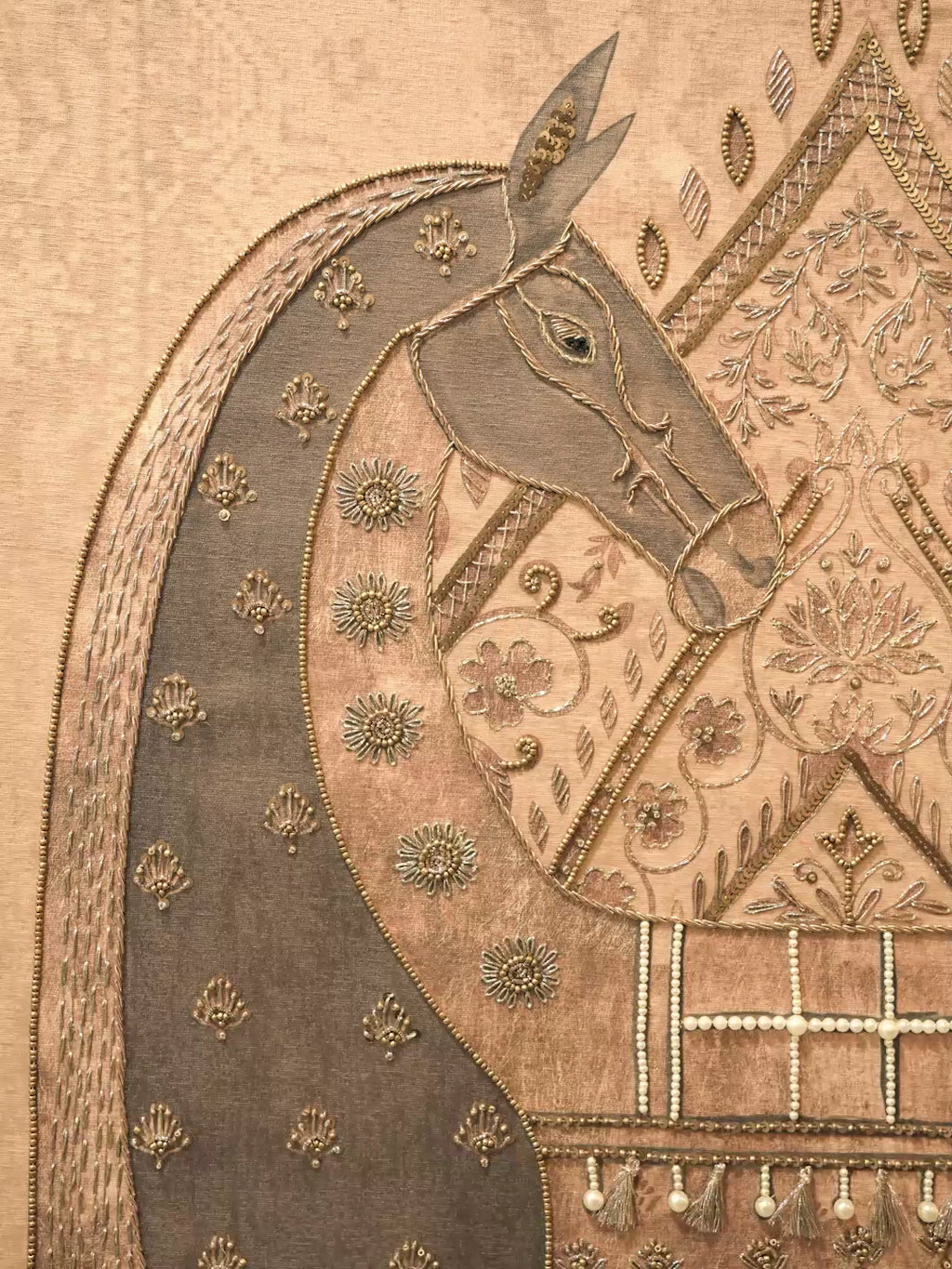 Swarna Ashwa embroidered wall art: an ornamented horse in bronze and gold, the framed piece, and close-ups of tassels and floral beadwork